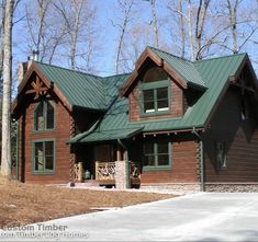 a large log home with a green roof