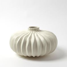 a white vase sitting on top of a table