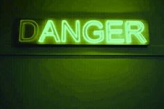 a neon sign that says danger on the wall