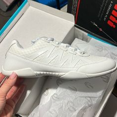 a white shoe is in a box on the table next to it's packaging