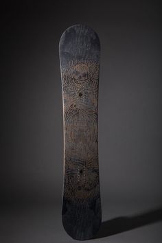 a black and brown skateboard with an intricate design on the bottom half of it