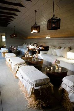 a living room filled with lots of white couches and tables next to each other