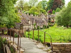 an old village with stone buildings and green grass