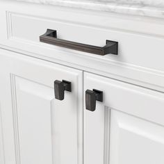 a white cabinet with two black handles on it