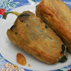 two fried food items on a plate with flowered design pattern and blue floral border