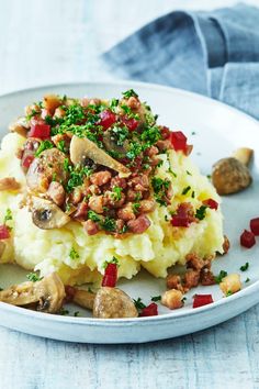 a white plate topped with mashed potatoes and mushrooms