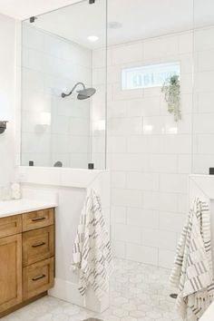 a bathroom with white tile and wooden cabinets