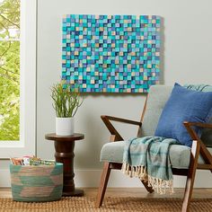 a living room scene with focus on the chair and wall art hanging over the couch