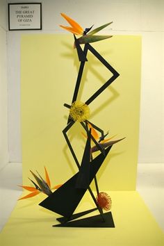 an artistic sculpture made out of paper with birds on it's legs and arms