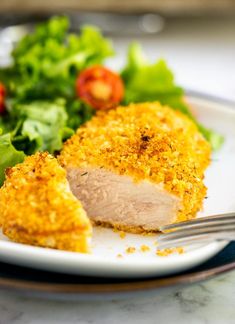 a close up of a plate of food with meat and salad on the other side