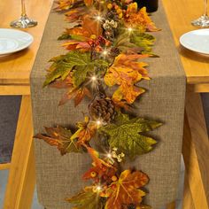 the table is decorated with autumn leaves and pine cones