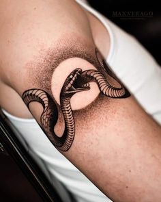 a man's arm with a snake tattoo on it