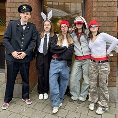 four people dressed up in costumes posing for a photo outside the door of a building