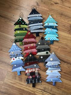 christmas tree ornaments made out of fabric on a wooden floor in various colors and patterns