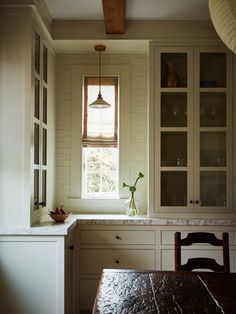 a kitchen with white cabinets and a wooden table