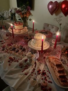 a table topped with lots of cakes and candles