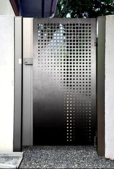 an open metal door on the side of a building with perfored glass panels