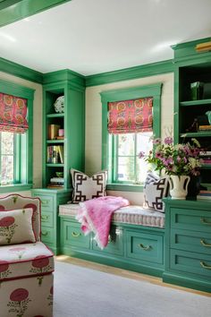 a living room with green painted walls and lots of furniture, including a bench in the center