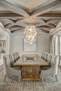 a dining room table with chairs and a chandelier hanging from it's ceiling