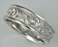 a wedding ring with intricate designs on the inside and outside, set in 18k white gold