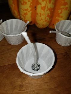 a white sink sitting on top of a wooden table next to two orange pumpkins