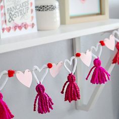 some tassels are hanging from a shelf with hearts and other decorations on it