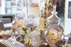 a table topped with lots of desserts and candies on top of it's sides