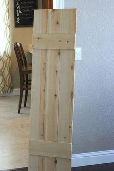 a wooden door is open in front of a dining room table