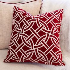 a red and white pillow sitting on top of a couch