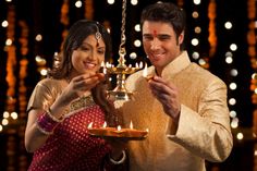 a man and woman holding a lit oil lamp