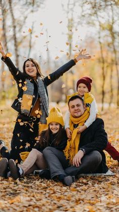 a family poses for a photo in the leaves