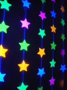 multicolored stars hanging from strings in the dark