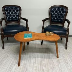 two chairs and a table with a book on it