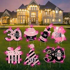 pink and black 30th birthday yard decorations in front of a large house at night with lights