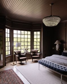 a large bed sitting in the middle of a bedroom next to two chairs and a table