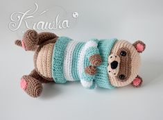 a crocheted stuffed animal laying on its side wearing a shirt and leggings