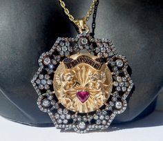 Vintage french ' il bat pour toi ' the 70's charm pendant set 1 heart cut natural ruby 0.30 ct ( dim 4 x 4 x 3 mm ) & 136 modern cut diamonds 0.01 ct & 48 modern cut diamonds 0.02 ct & 42 modern cut diamonds 0.03 ct & 12 modern cut diamonds 0.03 ct & 6 modern cut diamonds 0.1 ct for a total of diamonds 0.98 ct, solid yellow gold 18k, weight 13.90 gr, center diameter 36 mm ( 1 1/2 inch ), movable cherubs, hallmarked : 1 eagle head french punch 750 ( gold 18k ), natural orange Collectible Medallion Jewelry For Valentine's Day, Luxury Pendant Jewelry For Anniversary Gift, Collectible Pendant Jewelry For Valentine's Day, Love Pendant, Eagle Head, Love Charms, Watch Chain, Diamond Fashion, Natural Ruby