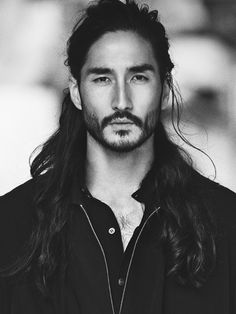 a man with long hair wearing a black shirt