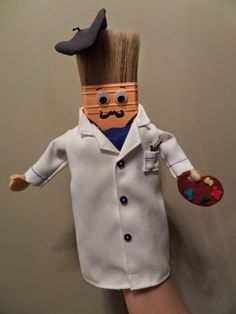 a hand holding a doll made to look like a doctor