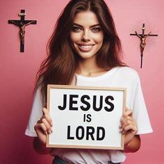 a woman holding up a sign that says jesus is lord