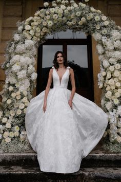 a woman standing in front of a doorway wearing a wedding dress