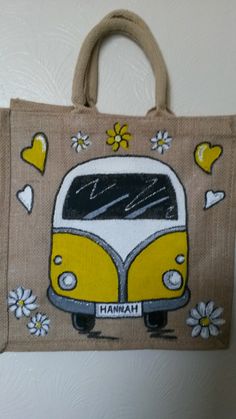 a yellow and white bus painted on the side of a brown tote bag with flowers