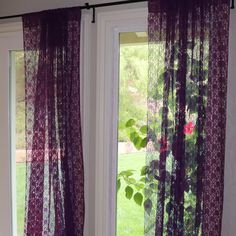 two purple curtains hanging in front of a window