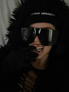 a woman wearing sunglasses and a furry hat