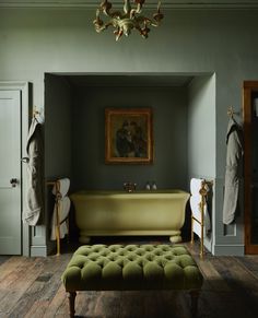 a bath room with a tub a chair and a painting