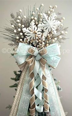 a christmas tree decorated with snowflakes and ribbons