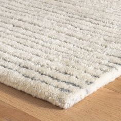 a white rug on top of a wooden floor next to a wood flooring board