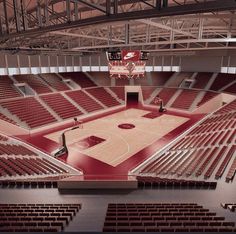 an empty basketball court with red seats