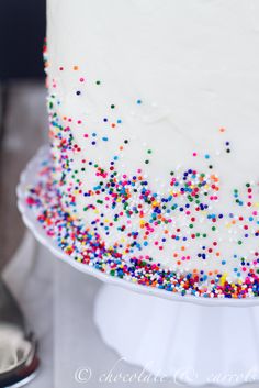 a cake with white frosting and colorful sprinkles