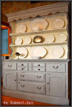 an old china cabinet with plates on it